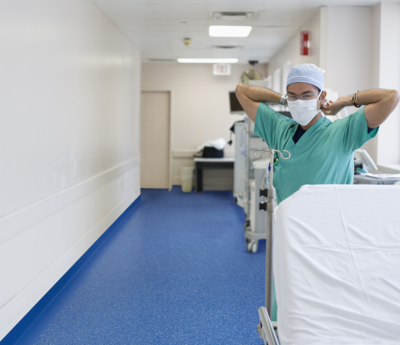 Korean doctor tying surgical mask in hospital corridor